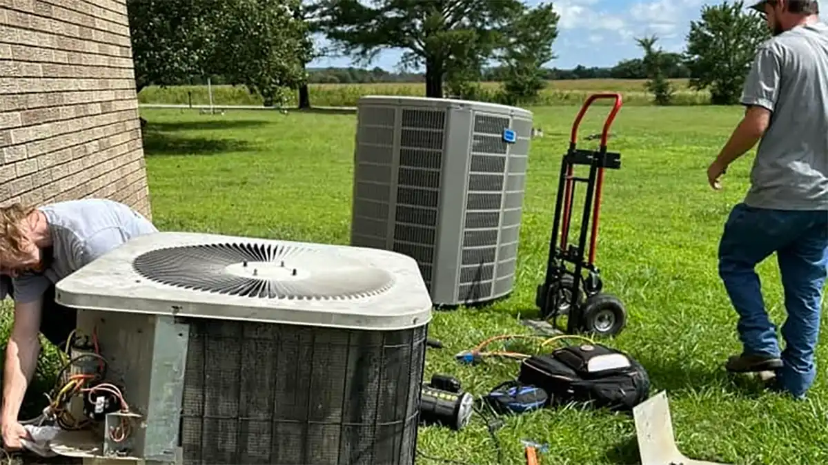 HVAC workers replacing and old air conditioning unit with a new one