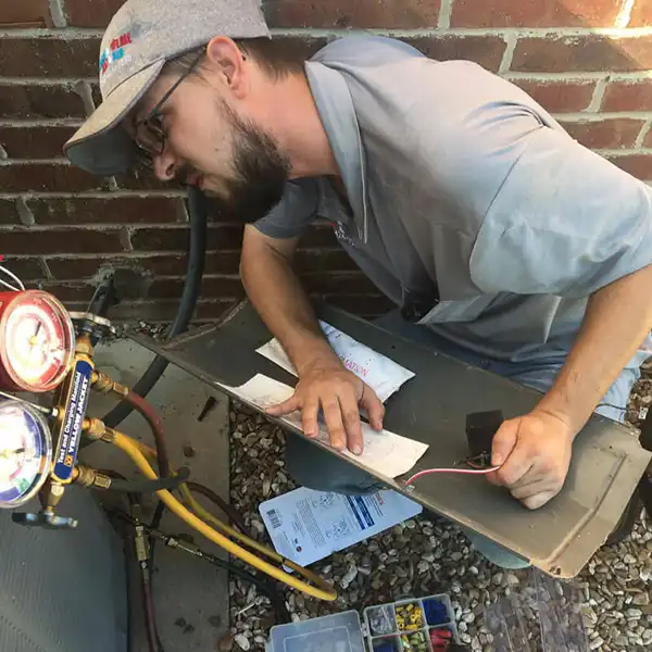 HVAC repairman performing air conditioning maintenance in McAlester, OK